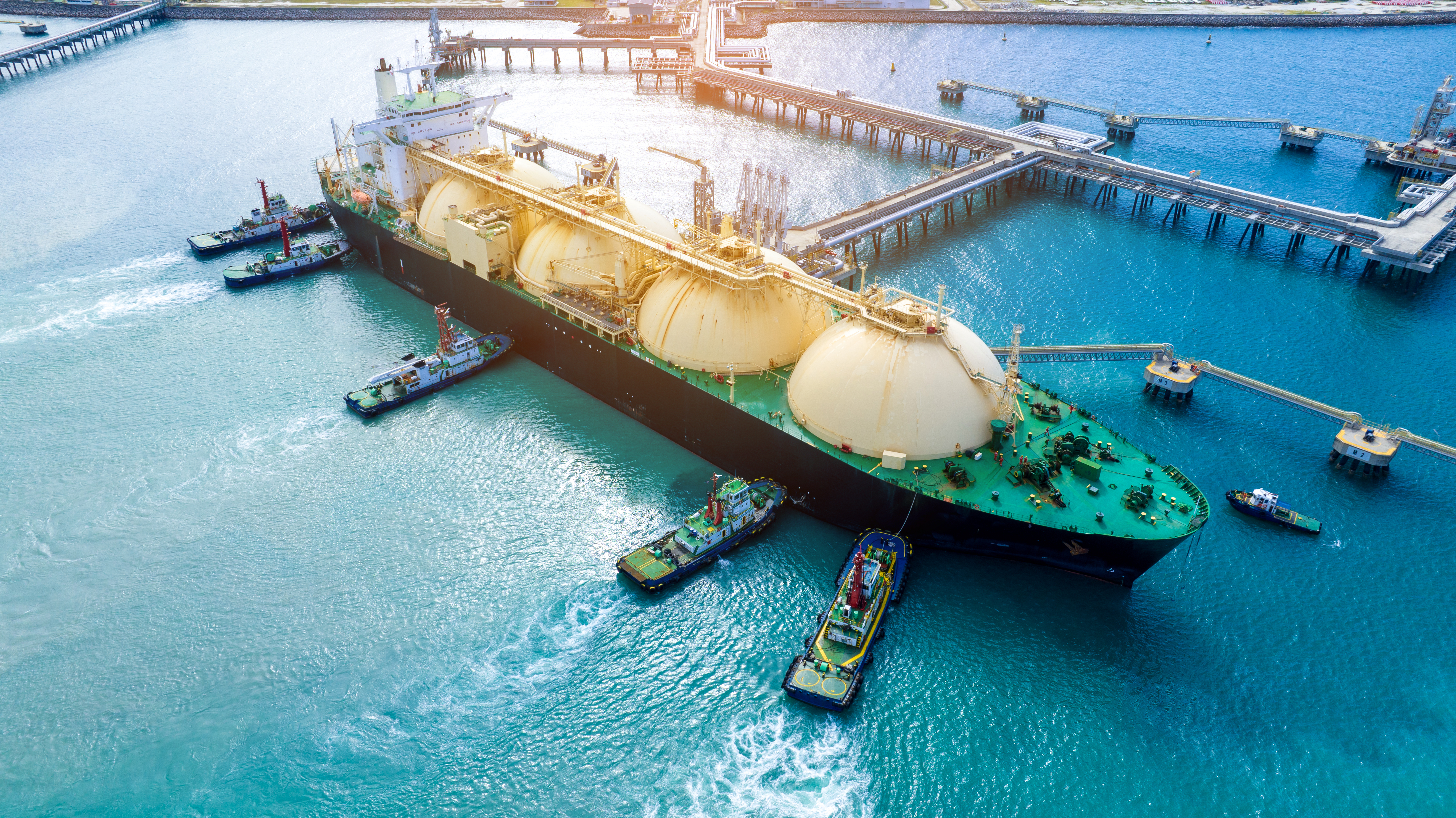 LNG (Liquefied natural gas) tanker anchored in Gas terminal gas tanks for storage. Oil Crude Gas Tanker Ship. LPG at Tanker Bay Petroleum Chemical or Methane freighter export import transportation
